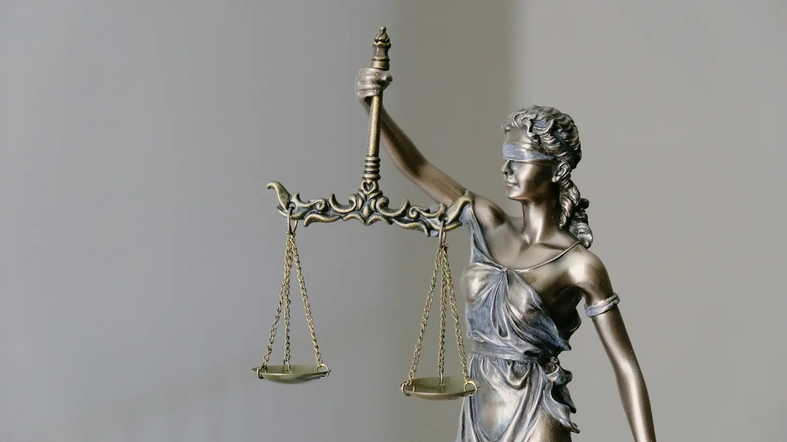 Estátua da Justiça em bronze sobre fundo neutro