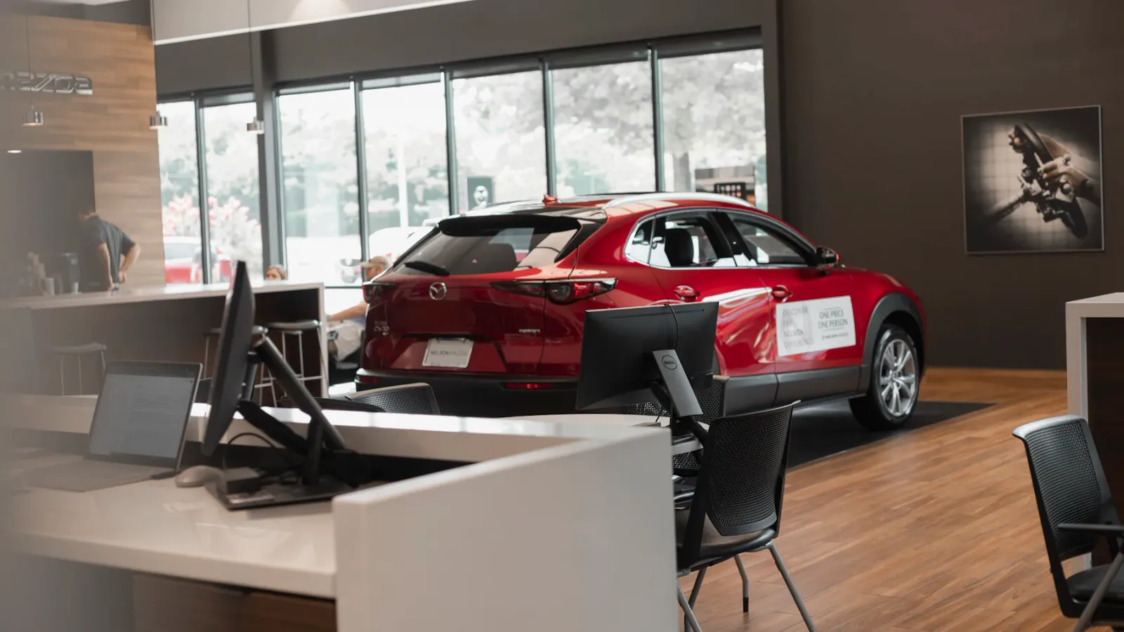 SUV vermelho exposto no showroom, visto da recepção