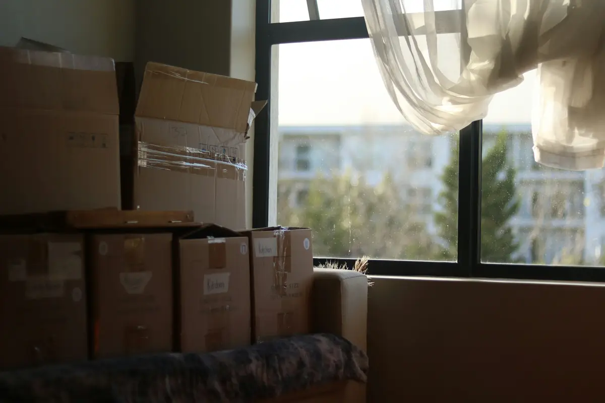 Caixas de mudança empilhadas ao lado da janela do apartamento