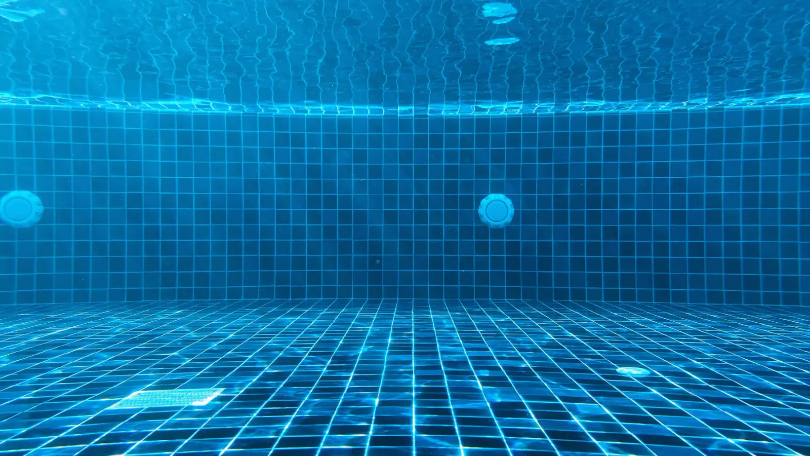 Água azul e limpa da piscina com azulejos ao fundo